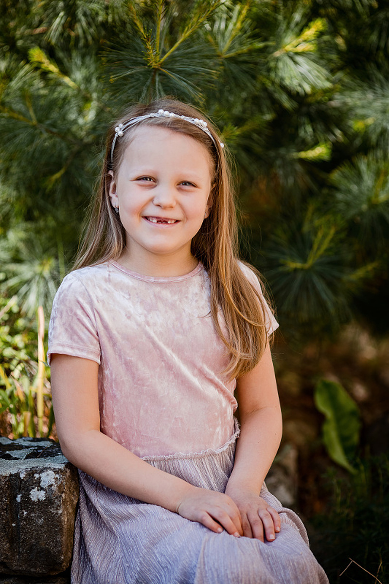 Dívka v jemně růžových šatech — ukázka vhodného oblečení na školkové focení